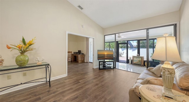 living room featuring high vaulted ceiling, wood finished floors, visible vents, and baseboards