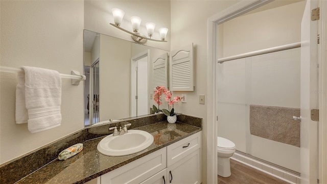 bathroom with vanity, toilet, and a stall shower