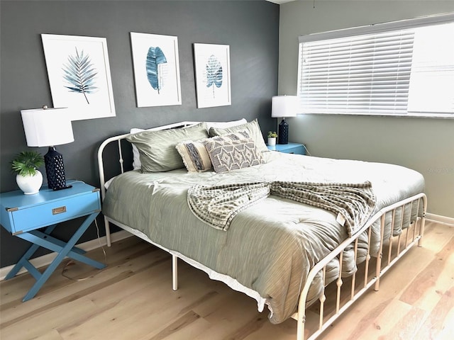 bedroom with baseboards and wood finished floors