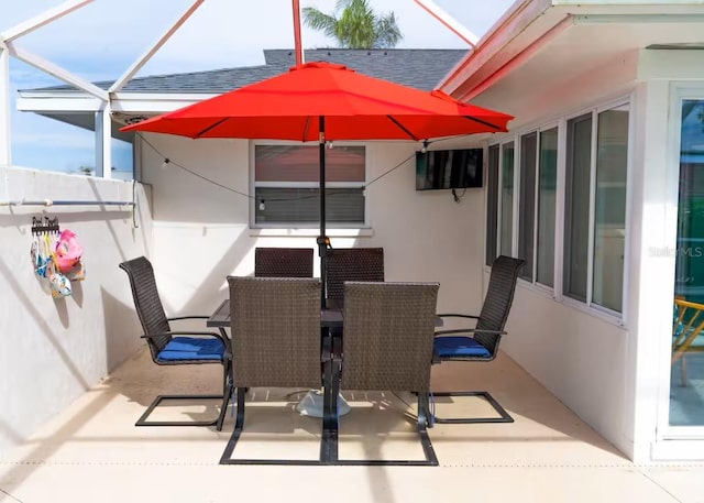 view of patio with outdoor dining area and a lanai