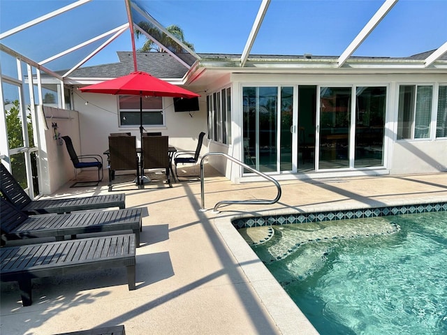 pool with a patio, outdoor dining space, and a lanai