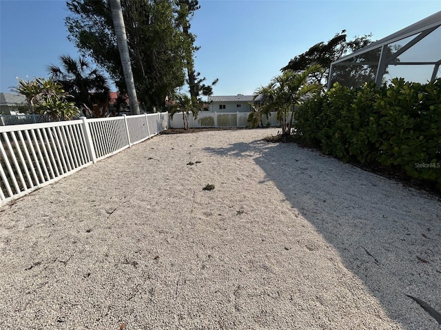 view of yard with glass enclosure and a fenced backyard