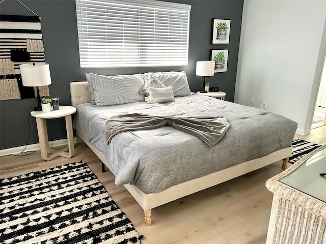 bedroom with baseboards and wood finished floors