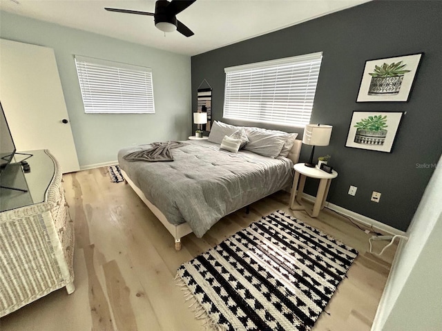 bedroom featuring ceiling fan, baseboards, and wood finished floors