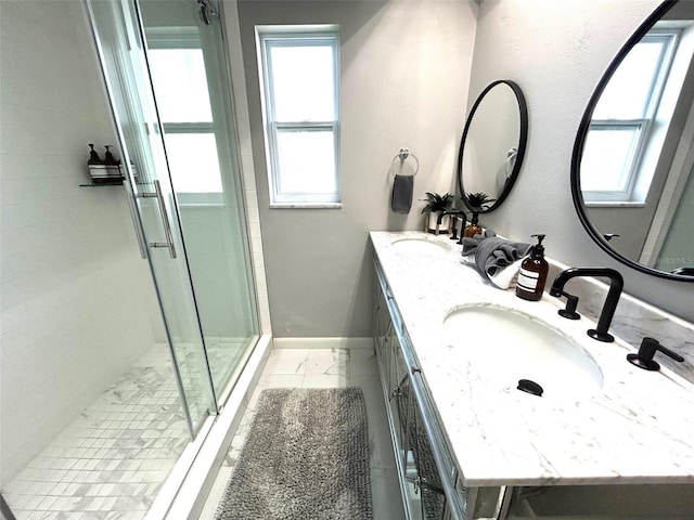 bathroom featuring a sink, a shower stall, baseboards, and double vanity