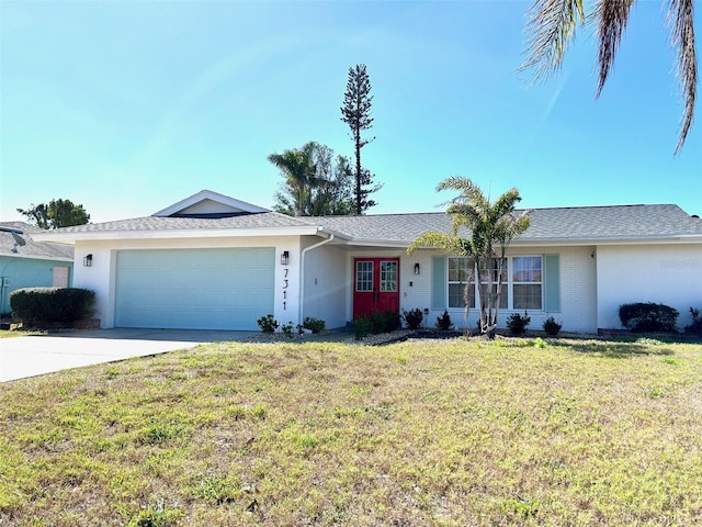 single story home with driveway, brick siding, an attached garage, a front lawn, and stucco siding