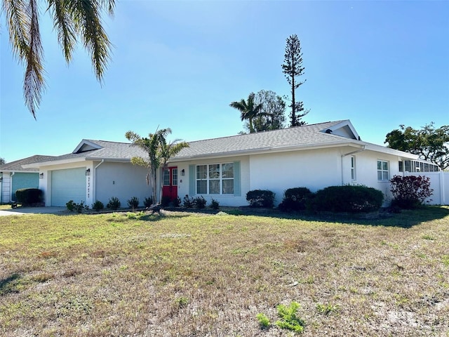 single story home featuring a garage, stucco siding, driveway, and a front yard