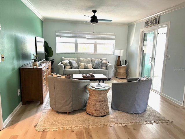 living area featuring a healthy amount of sunlight, crown molding, and wood finished floors