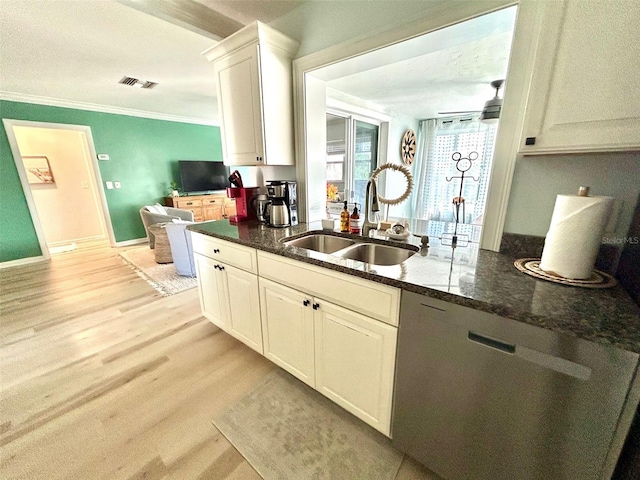 kitchen with visible vents, dark stone counters, light wood-style flooring, crown molding, and a sink