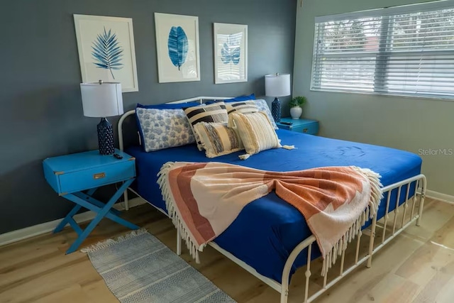 bedroom with baseboards and wood finished floors