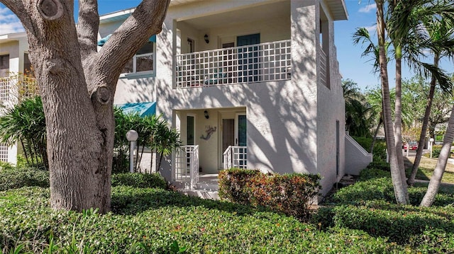 view of front of house with a balcony and stucco siding