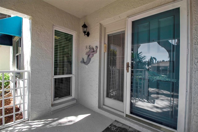 view of exterior entry featuring stucco siding