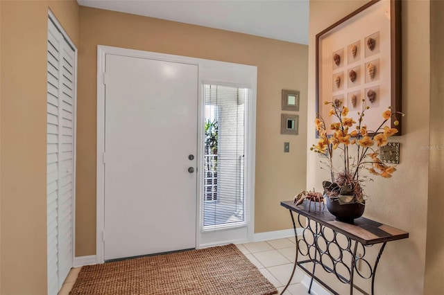 entryway with light tile patterned flooring and baseboards