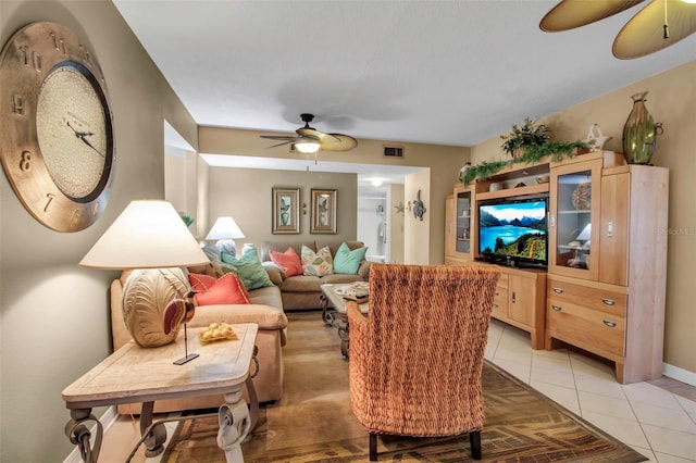 living room with light tile patterned floors, visible vents, and a ceiling fan