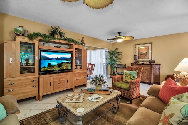 living room with a ceiling fan, a textured ceiling, and light tile patterned floors