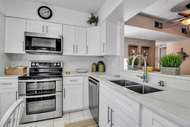 kitchen with visible vents, ceiling fan, stainless steel appliances, white cabinetry, and a sink