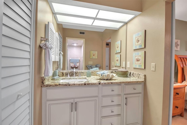 bathroom with a skylight, visible vents, and vanity