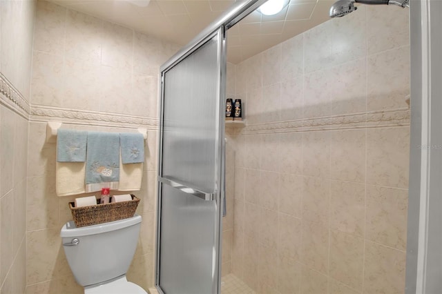 full bathroom featuring toilet, a stall shower, and tile walls