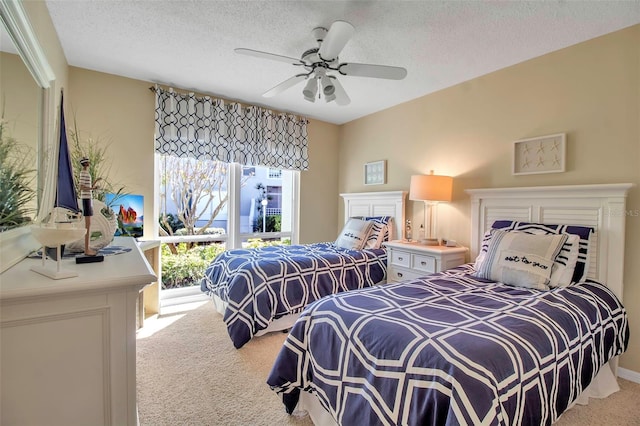 bedroom with light carpet, ceiling fan, and a textured ceiling