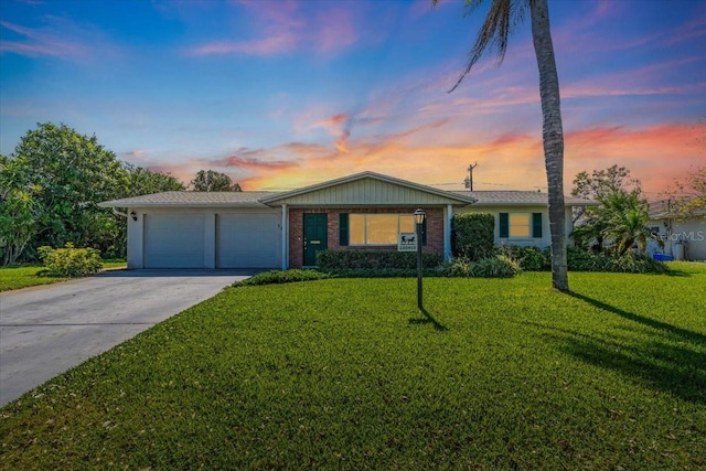 ranch-style house with an attached garage, a front lawn, concrete driveway, and brick siding