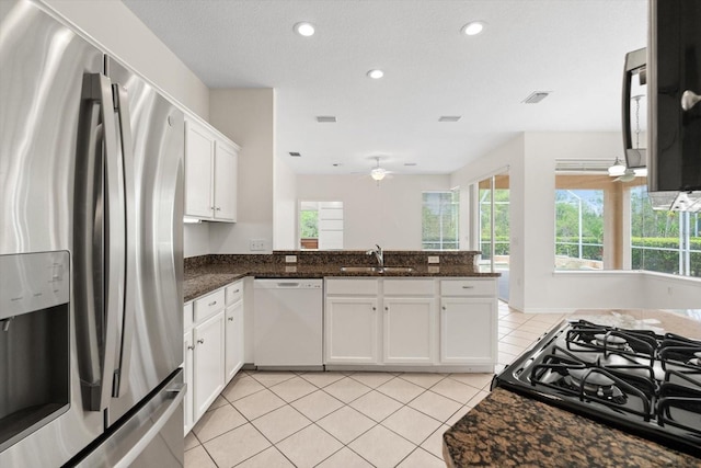 kitchen with light tile patterned floors, a sink, a wealth of natural light, stainless steel fridge with ice dispenser, and dishwasher