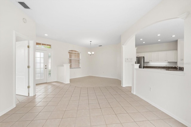 unfurnished living room with light tile patterned floors, baseboards, visible vents, an inviting chandelier, and recessed lighting