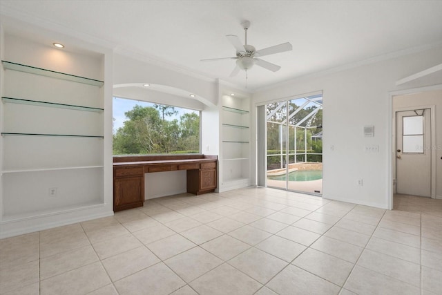 unfurnished room featuring built in features, crown molding, a ceiling fan, a sunroom, and light tile patterned flooring