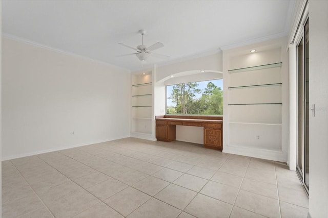 spare room featuring light tile patterned floors, built in shelves, ornamental molding, and built in study area