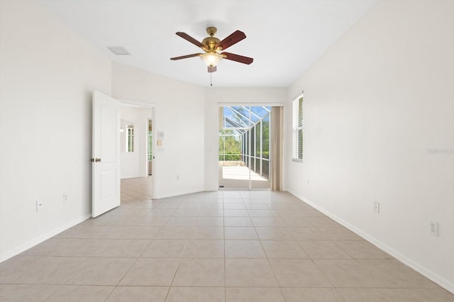 spare room featuring light tile patterned floors, ceiling fan, visible vents, and baseboards