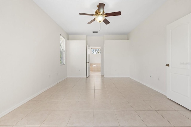 interior space featuring visible vents, light tile patterned flooring, a ceiling fan, and baseboards