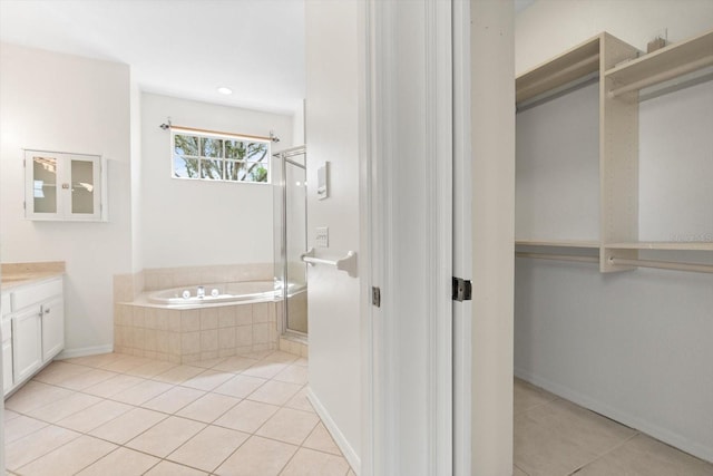 full bathroom with tile patterned floors, a stall shower, vanity, baseboards, and a bath