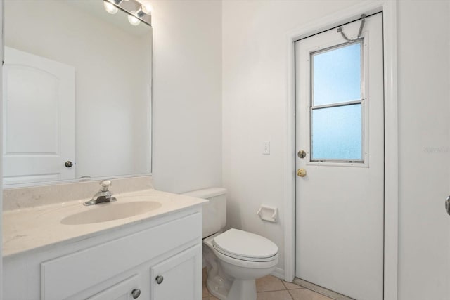 bathroom with tile patterned flooring, vanity, and toilet