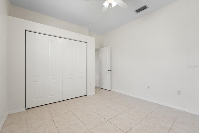 unfurnished bedroom with light tile patterned floors, a ceiling fan, visible vents, baseboards, and a closet