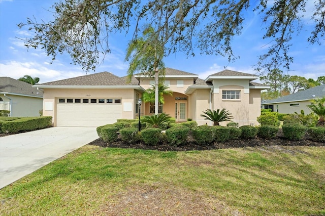 view of front of house with a garage, concrete driveway, a front lawn, and stucco siding