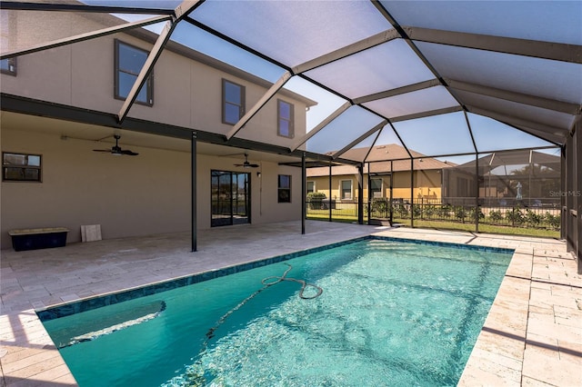 view of swimming pool with glass enclosure, a patio, a ceiling fan, and a fenced in pool