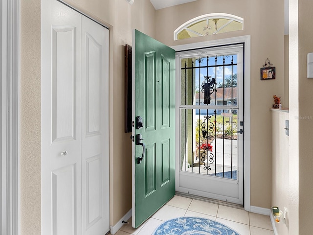 foyer with light tile patterned floors and baseboards