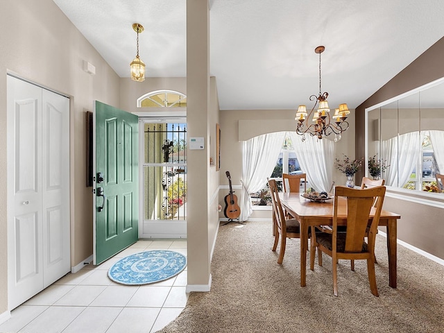 foyer featuring vaulted ceiling, plenty of natural light, light colored carpet, and a notable chandelier