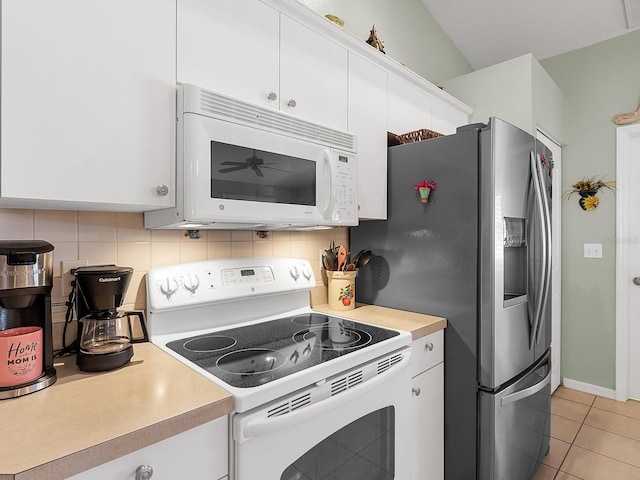 kitchen featuring light tile patterned flooring, white appliances, white cabinets, light countertops, and decorative backsplash