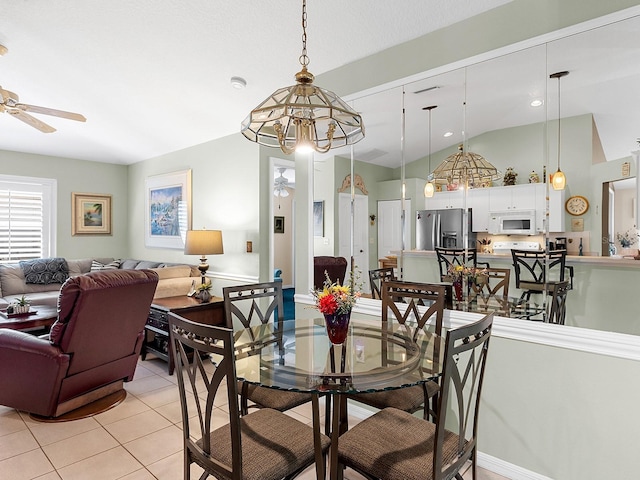 dining area with light tile patterned flooring, vaulted ceiling, and ceiling fan