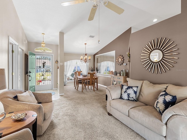 living room featuring light carpet, visible vents, baseboards, lofted ceiling, and ceiling fan with notable chandelier