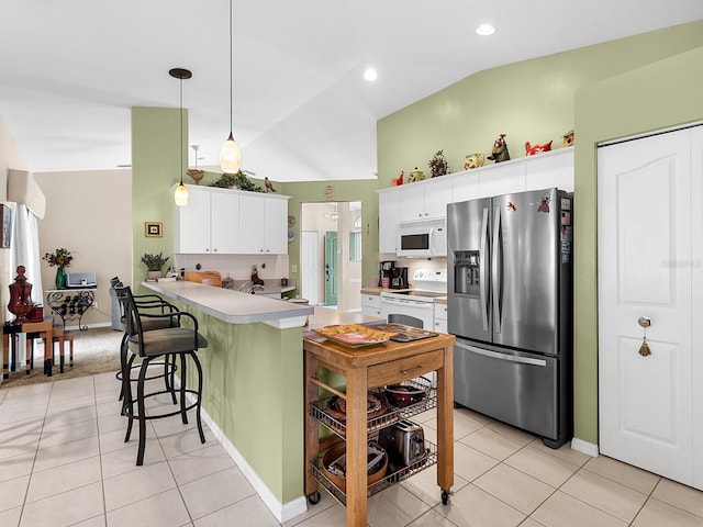 kitchen with white appliances, light tile patterned floors, lofted ceiling, a peninsula, and light countertops