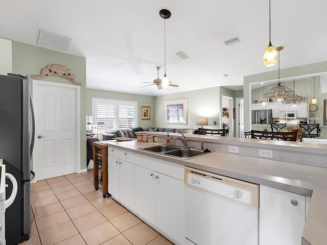 kitchen featuring open floor plan, white appliances, a sink, and visible vents