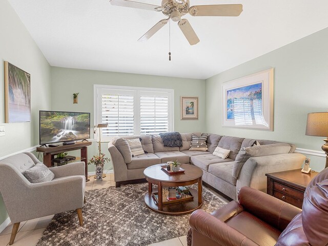 living area with tile patterned flooring, ceiling fan, and baseboards