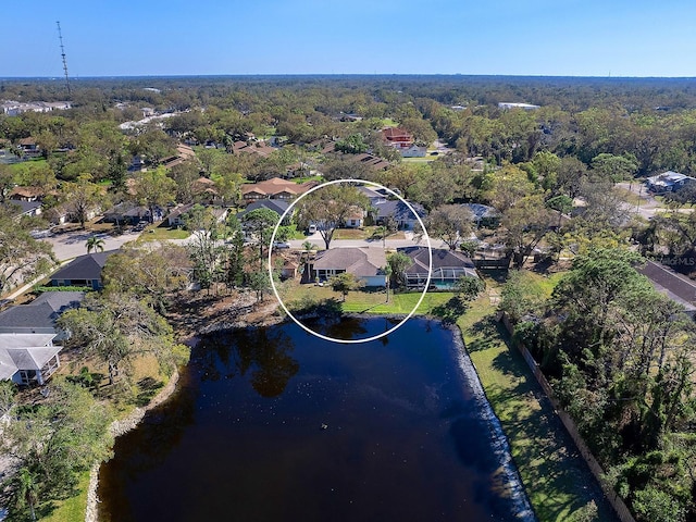 drone / aerial view featuring a water view, a residential view, and a view of trees