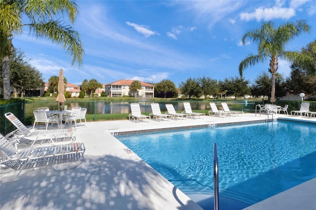 community pool with a patio area and fence