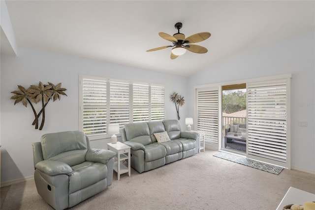 carpeted living area with ceiling fan and vaulted ceiling