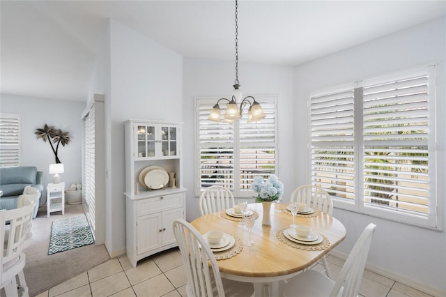 dining space with a chandelier, light tile patterned floors, and baseboards