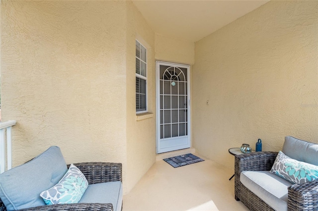 entrance to property featuring a patio and stucco siding