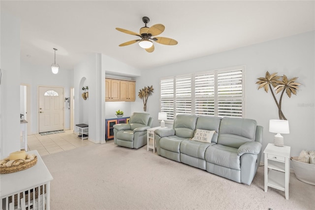 living room featuring lofted ceiling, light tile patterned flooring, a ceiling fan, and light carpet