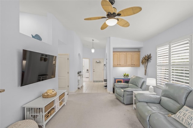 living area with light tile patterned floors, a ceiling fan, high vaulted ceiling, arched walkways, and light carpet